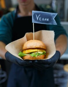 Vegan snacks - burger with text label in hands