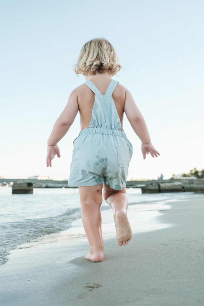 little-barefoot-toddler-in-summer-suit-walking-on-sandy-beach.jpg