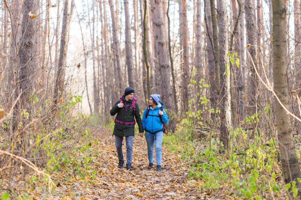 travel-tourism-hike-and-nature-concept-tourists-walking-in-park-with-backpack-dressed-in-blue.jpg