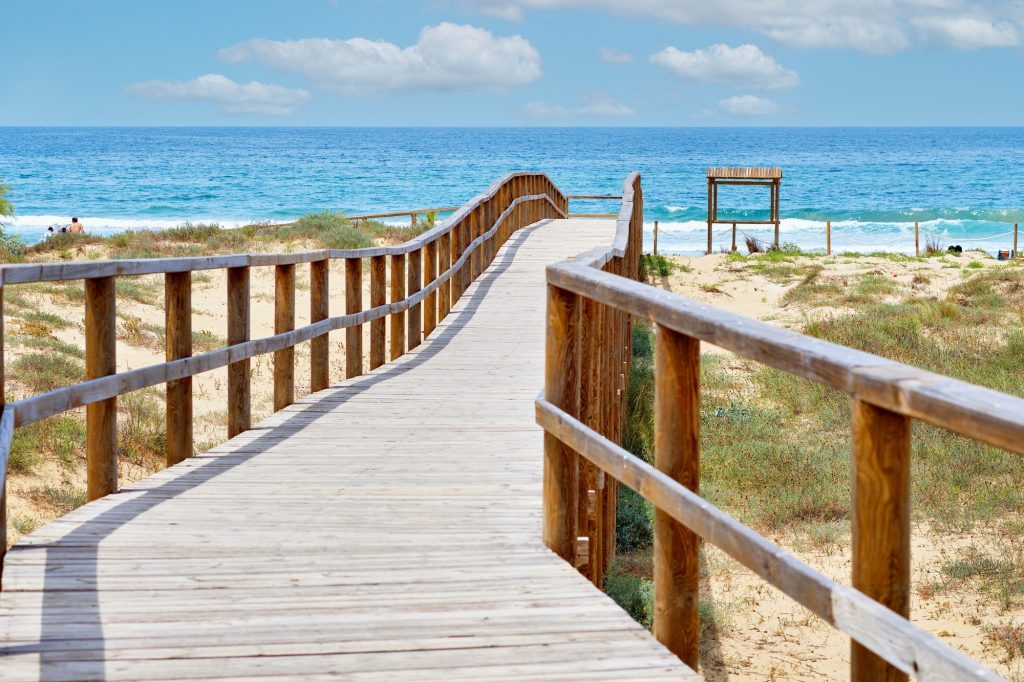 wooden-empty-board-walk-leading-to-mediterranean-sea-and-beach-of-los-arenales-arenals-del-sol-spain.jpg