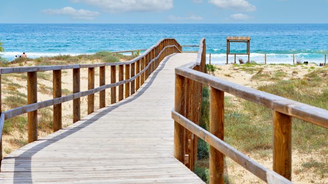 wooden-empty-board-walk-leading-to-mediterranean-sea-and-beach-of-los-arenales-arenals-del-sol-spain.jpg