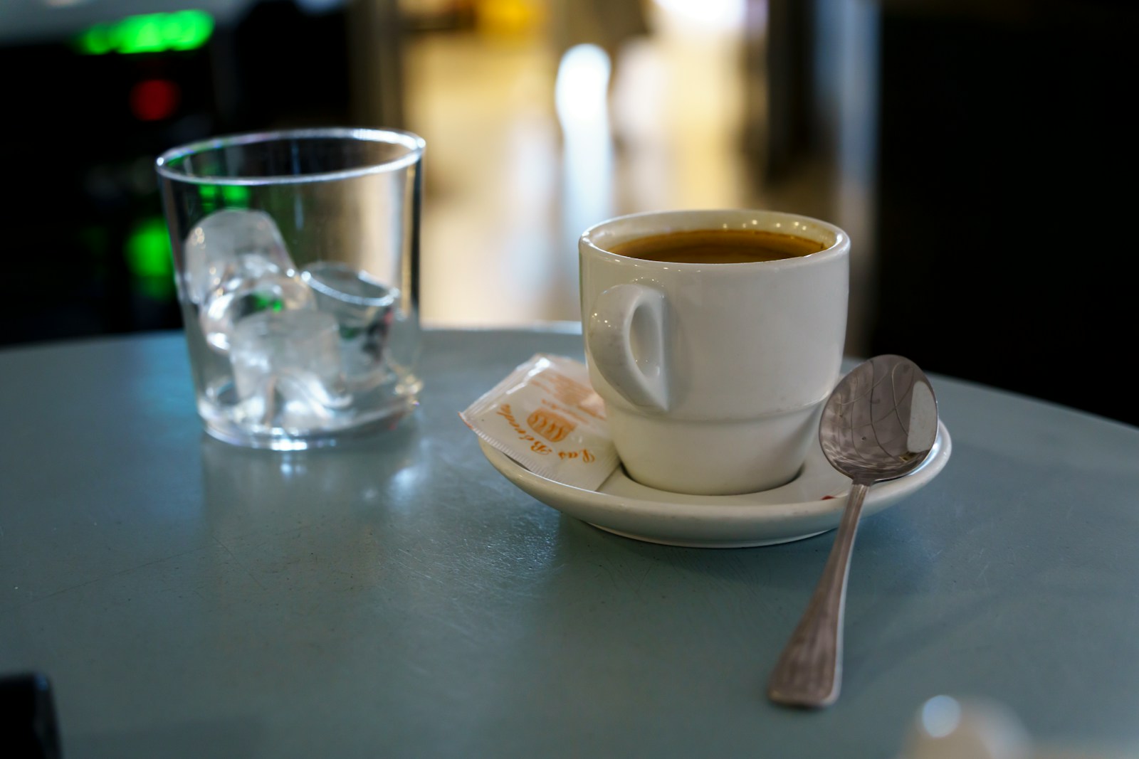 A cup of coffee and a spoon on a table